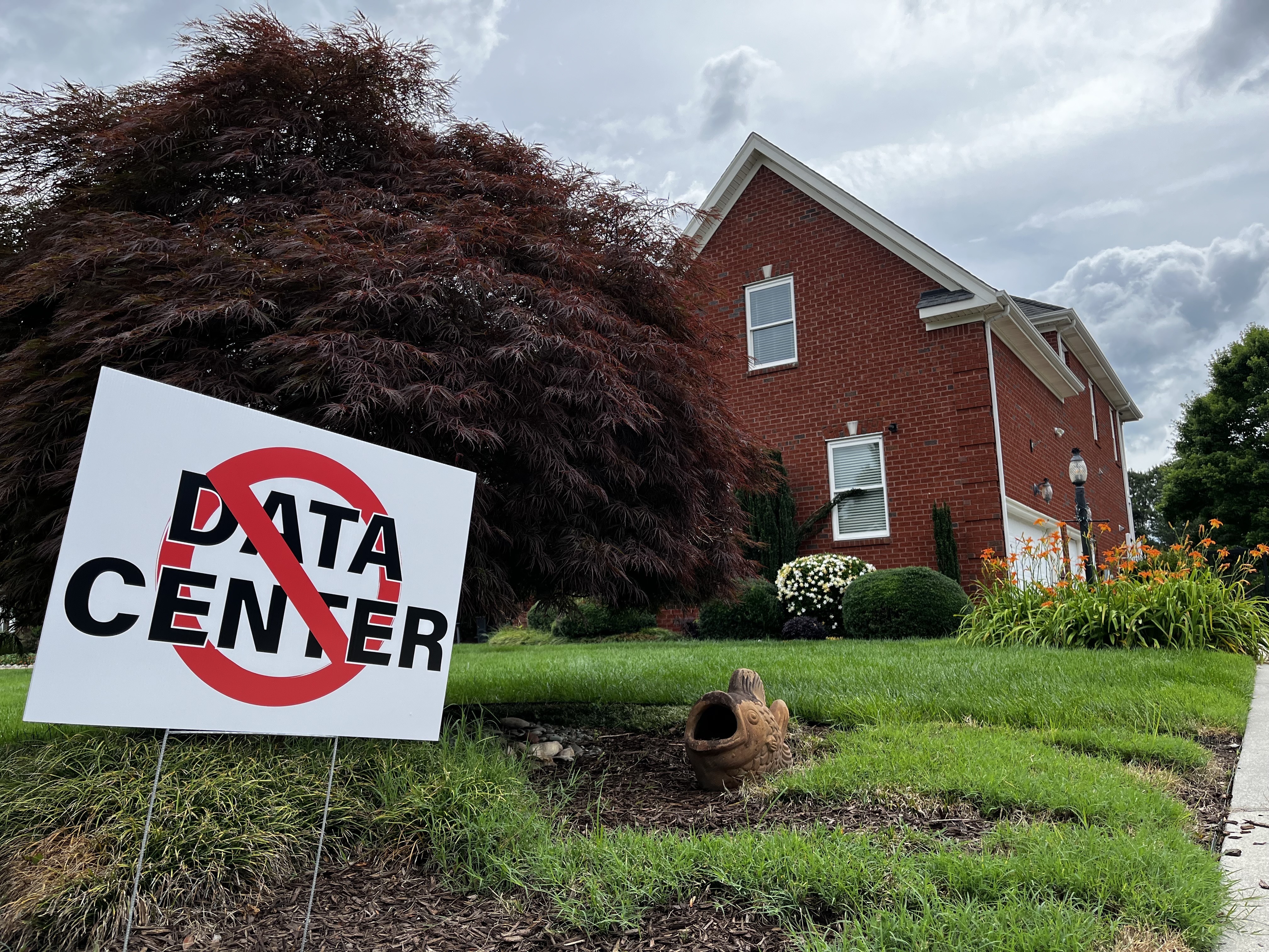 The yard of a house in Chesapeake, Va., displays a sign opposing the construction of data centers.