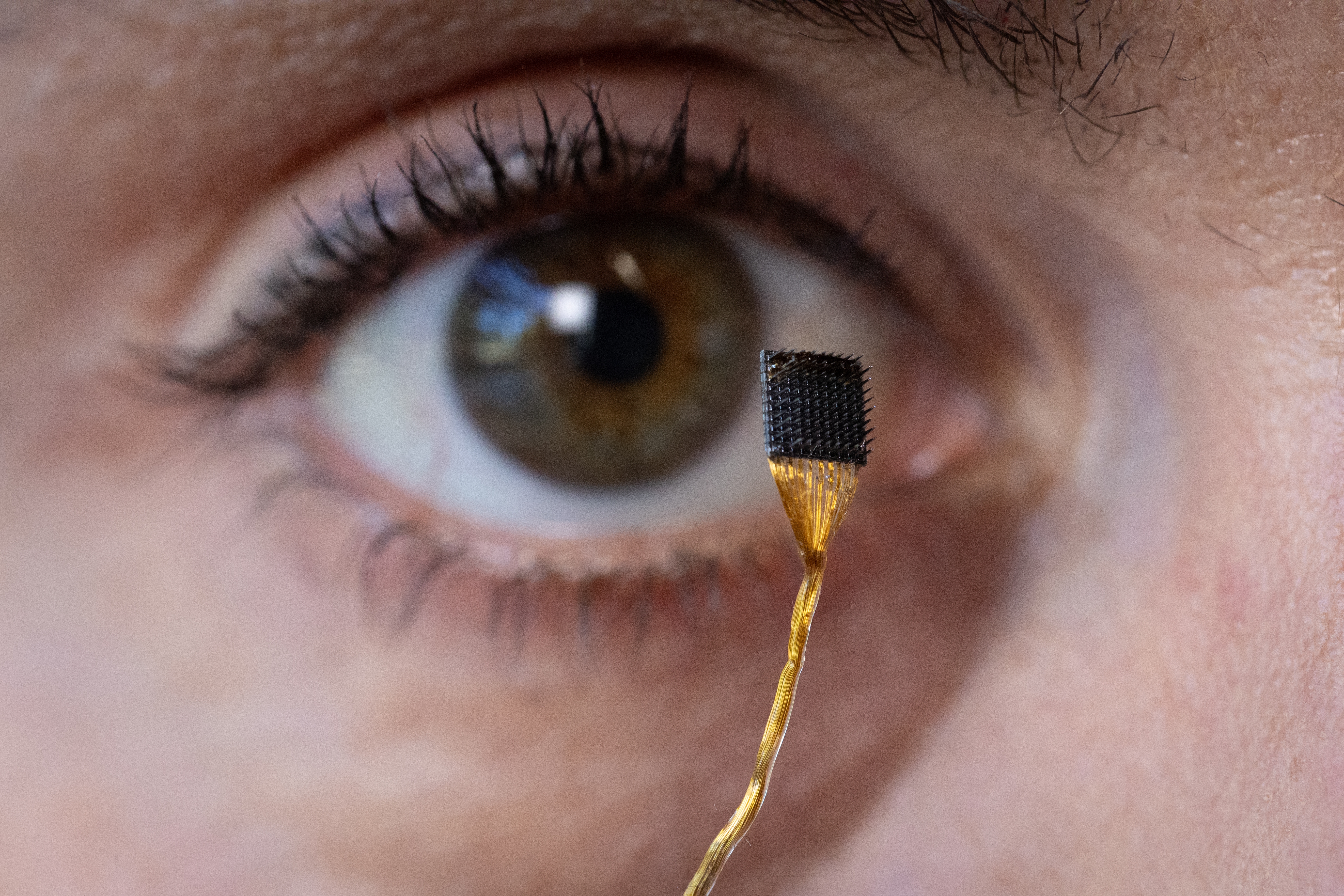 Postdoctoral researcher Erin Kunz holds up a microelectrode array that can be placed on the brain