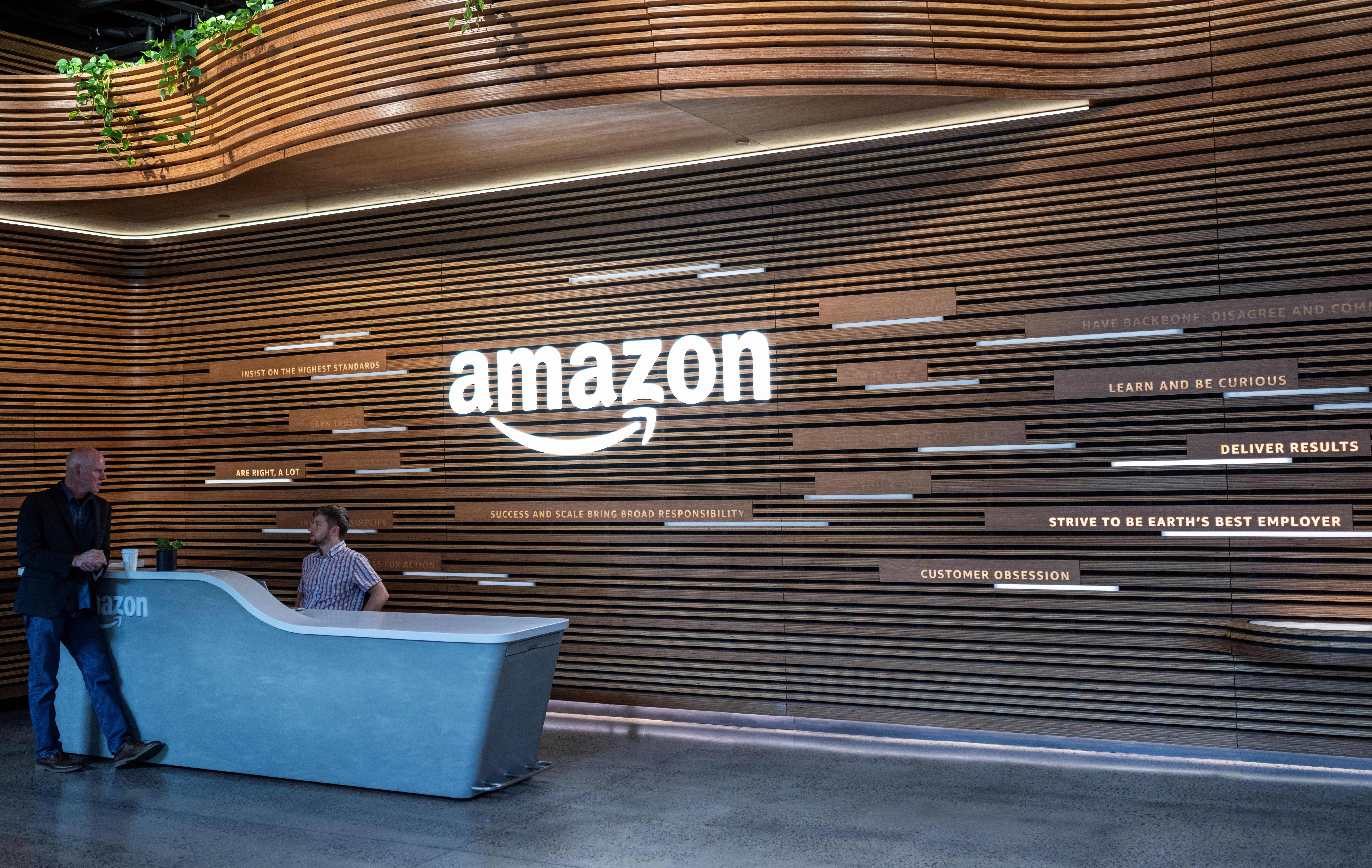 Two Amazon employees talk at one of the entrances to the company