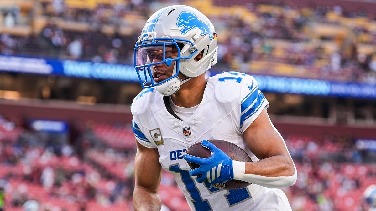 Amon-Ra St. Brown runs with football