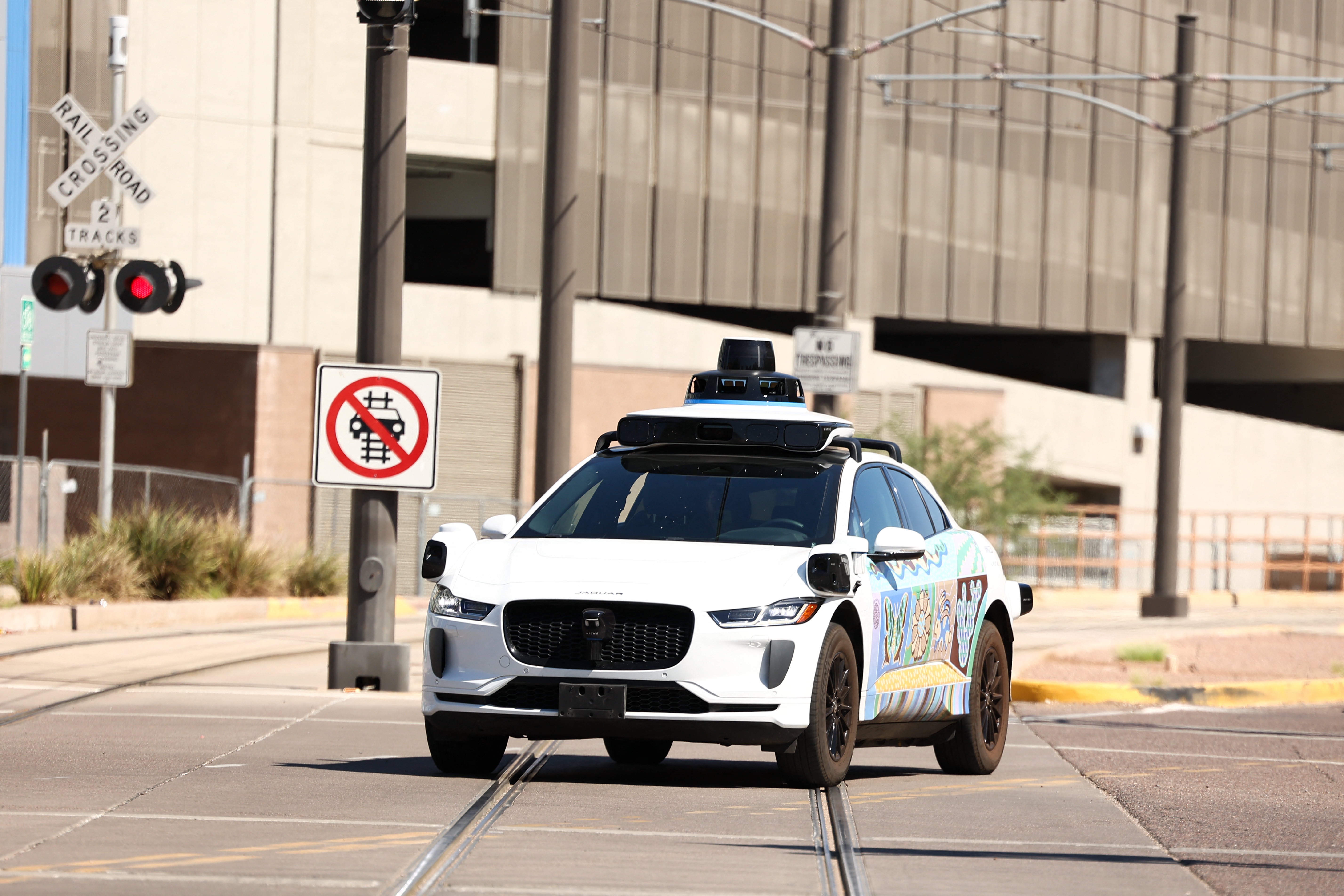A Waymo autonomous Jaguar electric vehicle is seen in Tempe, Ariz., on the outskirts of Phoenix, on Sept. 15. The company is recalling software for its robotaxis after reports that some of them failed to stop for school buses.