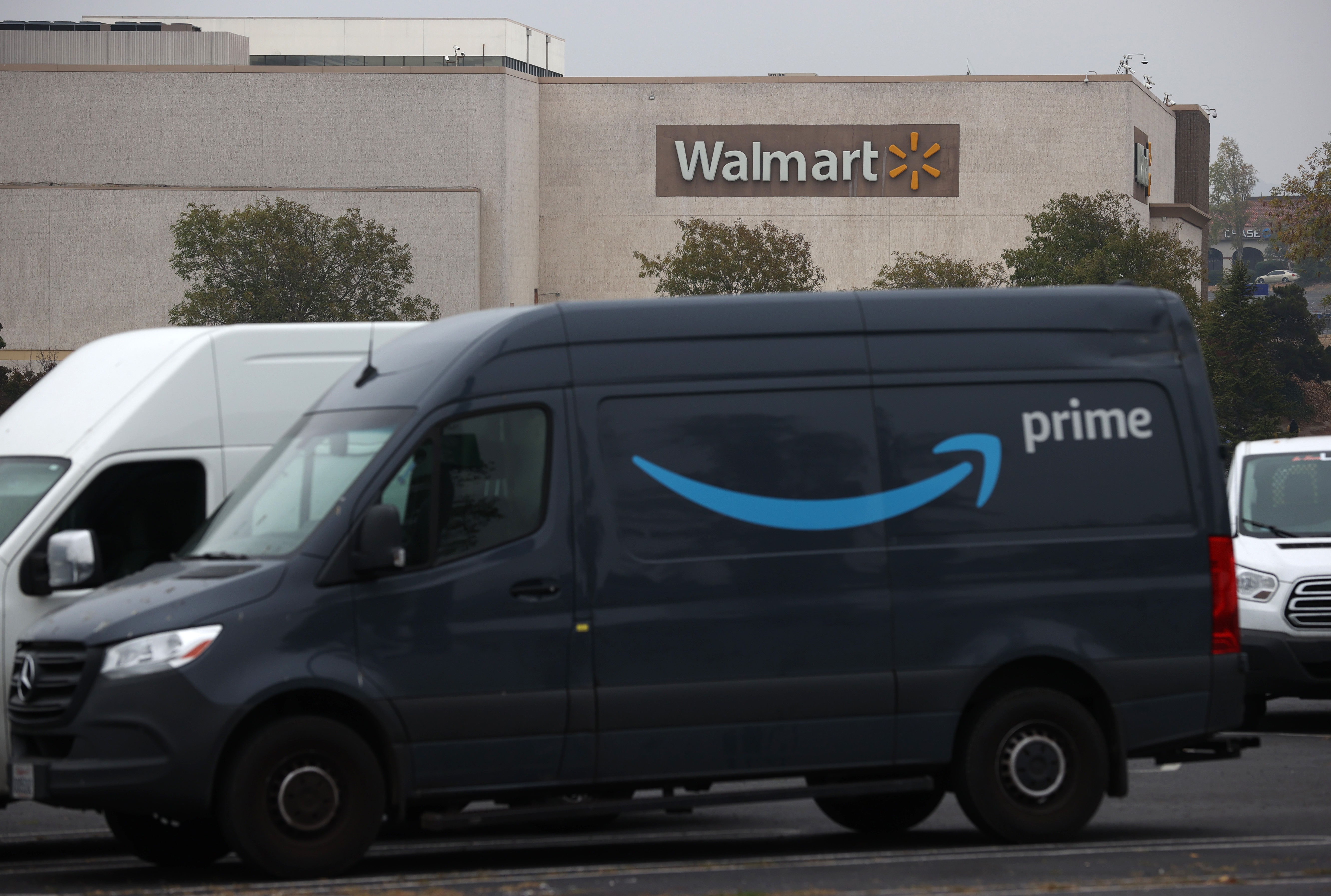 An Amazon Prime delivery van sits parked near a Walmart store in California.
