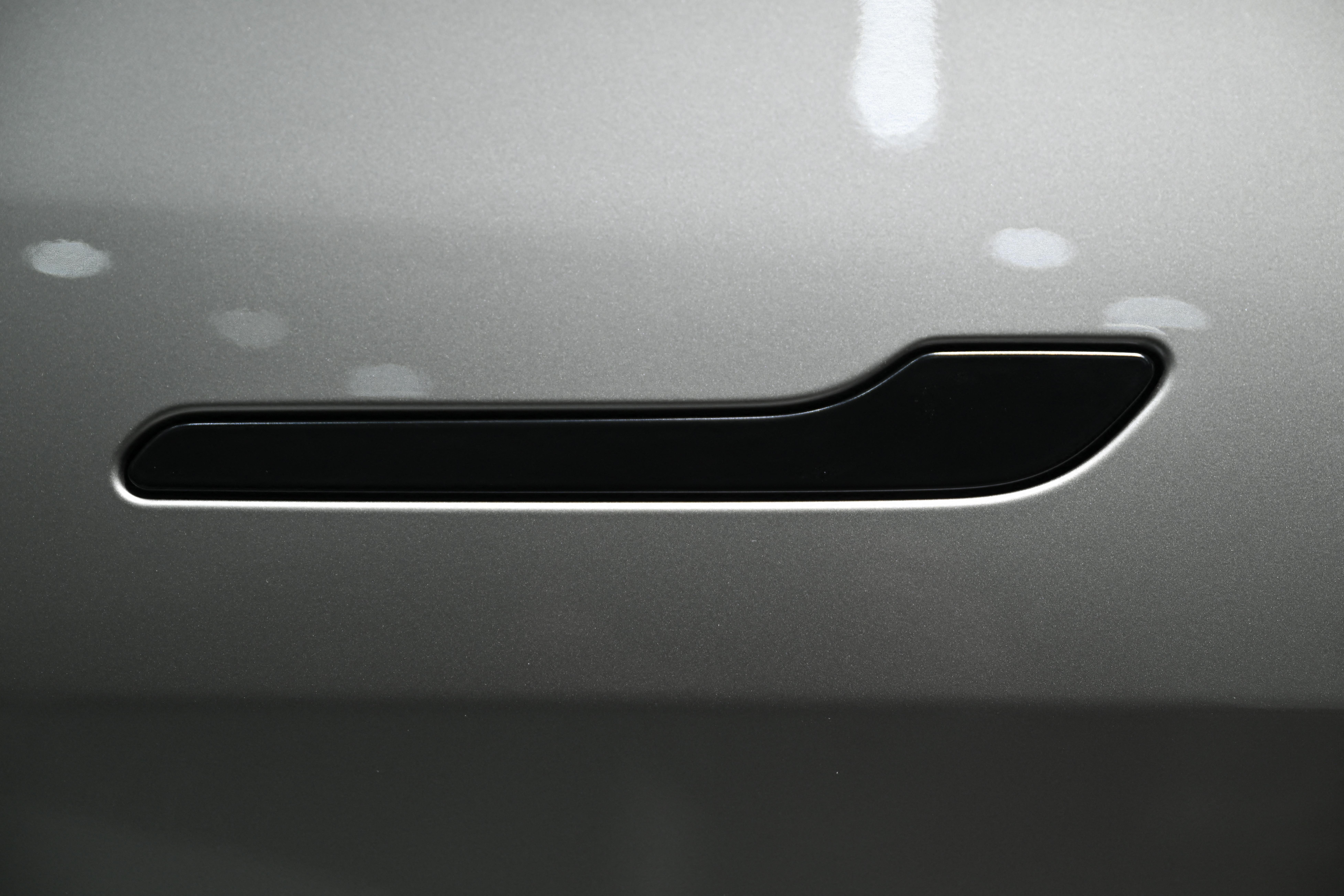 The handle of a Tesla Model Y electric vehicle sits flush against the vehicle