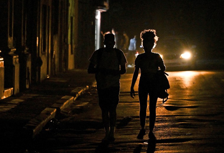 Cubans walk down a dark street during a blackout in Havana on March 4, 2026.