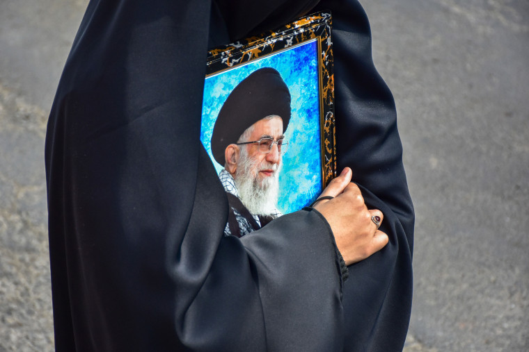 A Kashmiri Shiite Muslim protester holds a photograph of the