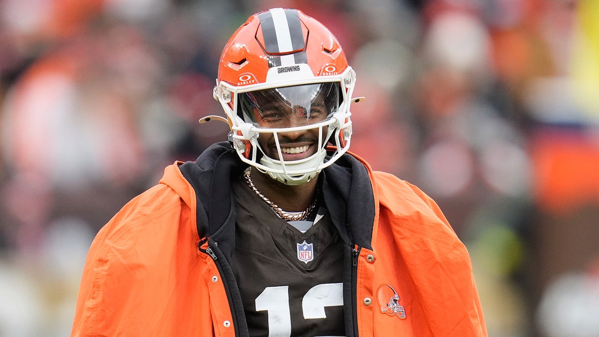 Shedeur Sanders smiles on the sideline