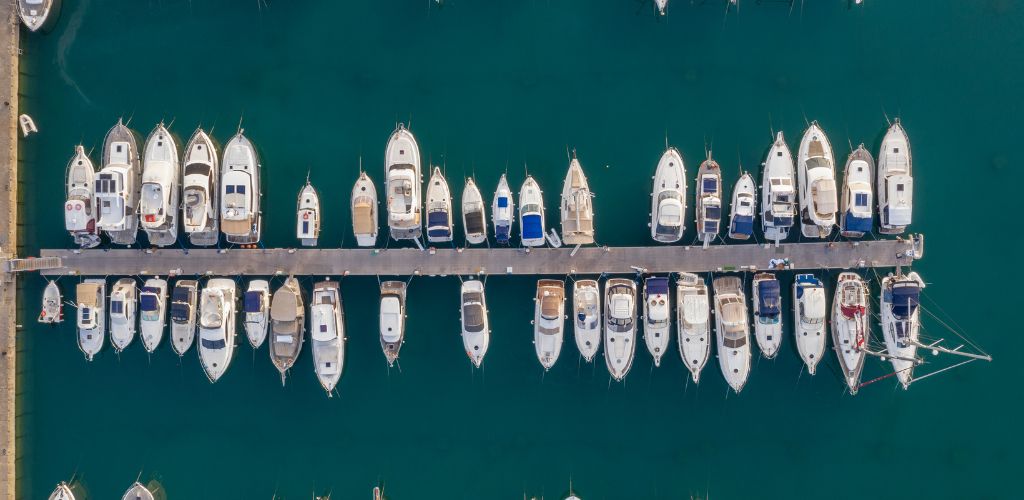Aerial image of a pathway leading into the water and a yacht marina.