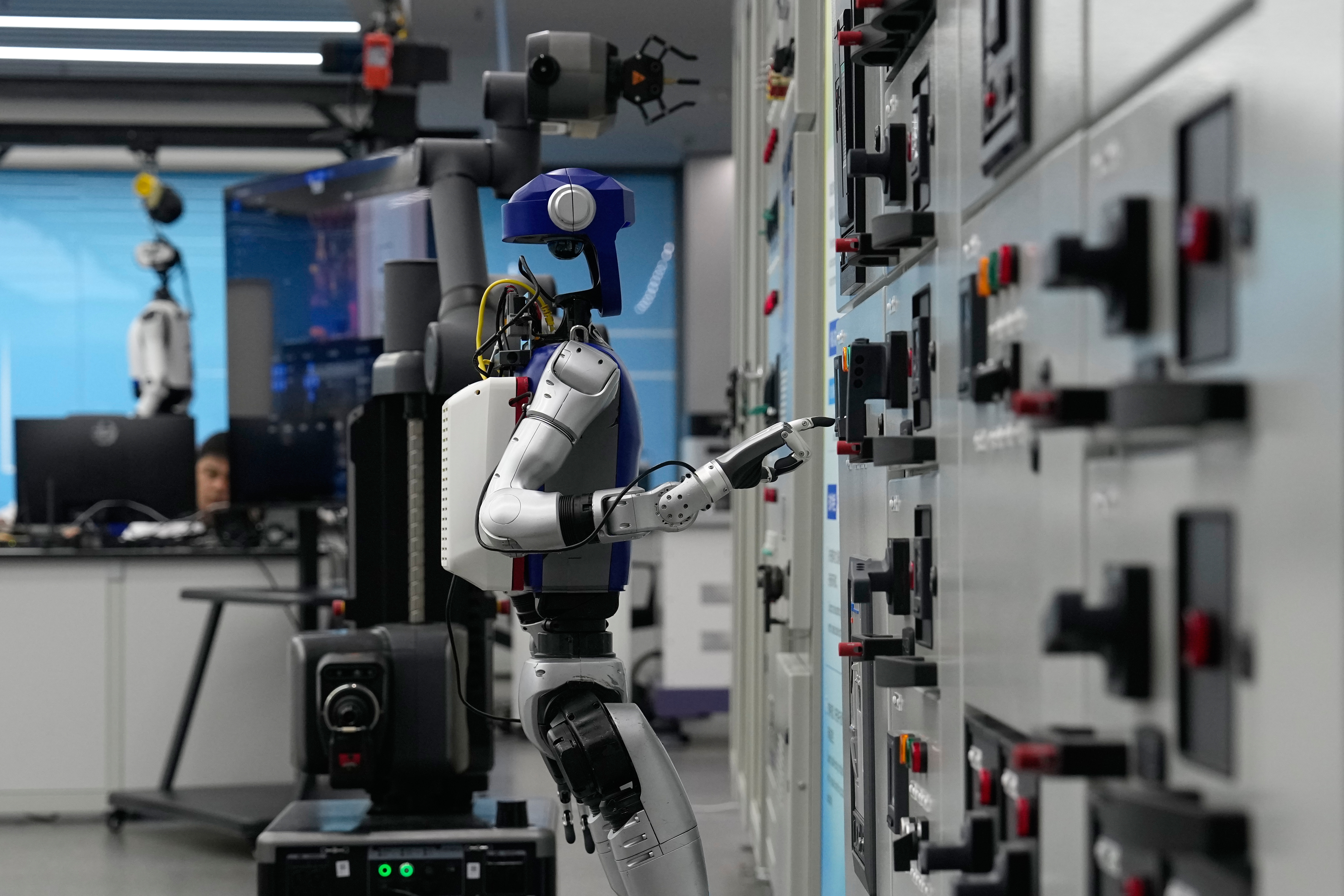 Artificial Intelligence robots demonstrate working on power grid control units during a media organized tour at Guangdong Power Grid Robotics Laboratory in Guangzhou, in southern China