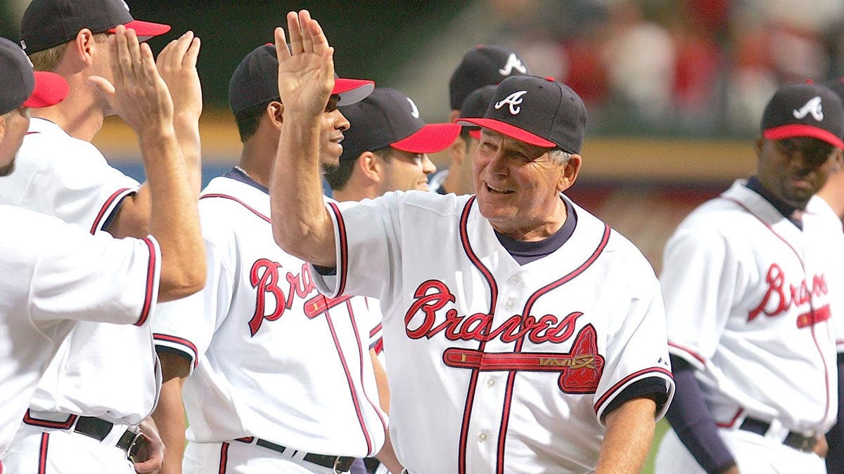 Manager Bobby Cox high fives teammates at Turner Field in Atlanta