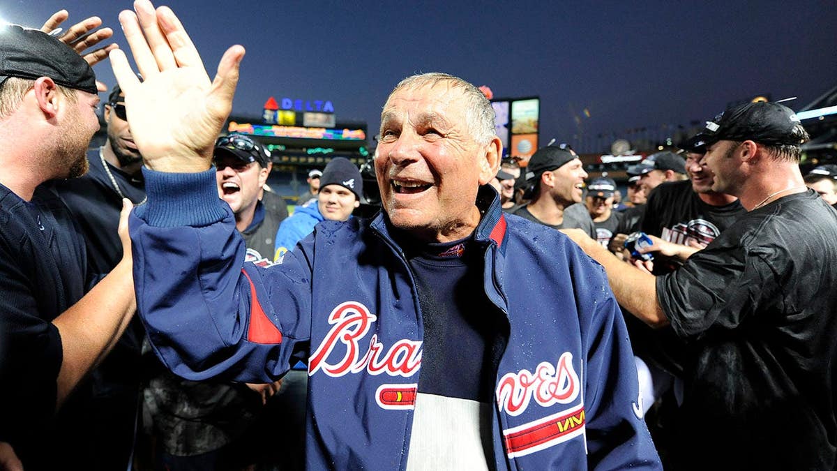 Atlanta Braves manager Bobby Cox celebrating with his team on the field