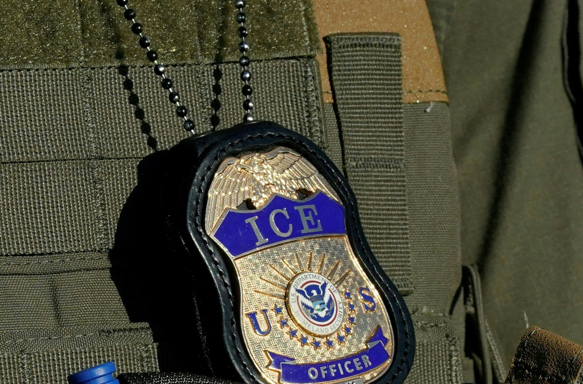 File image dated May 7, 2025 in Newark, New Jersey, shows a badge hanging over the uniform of an Immigration and Customs Enforcement (ICE) agent.