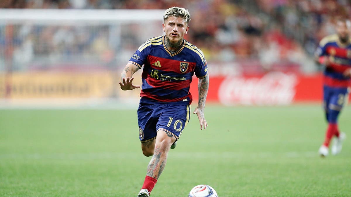 Diego Luna running with the ball during a soccer match at America First Field.