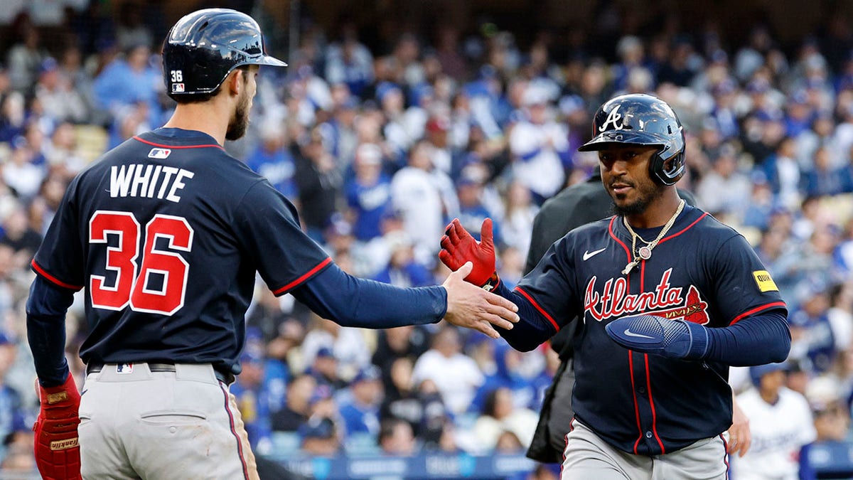 Atlanta Braves' Ozzie Albies and Eli White celebrating on the field during a baseball game