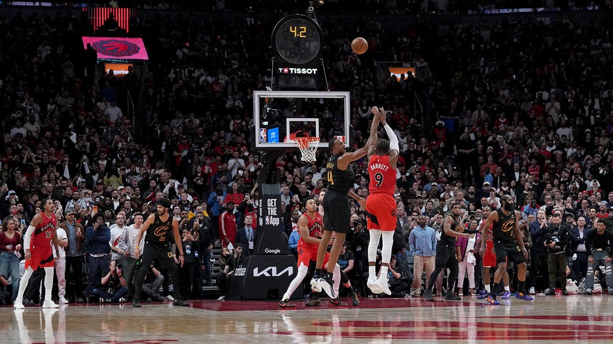 Toronto Raptors forward RJ Barrett shooting a basketball during overtime in a game.
