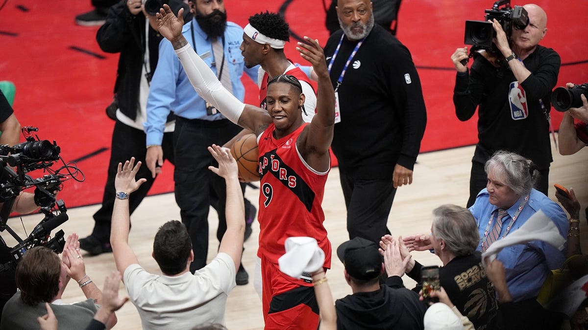 Toronto Raptors' RJ Barrett celebrating with fans after a win in Toronto