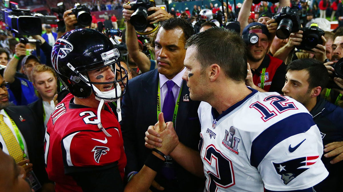 Matt Ryan and Tom Brady shaking hands on football field at NRG Stadium