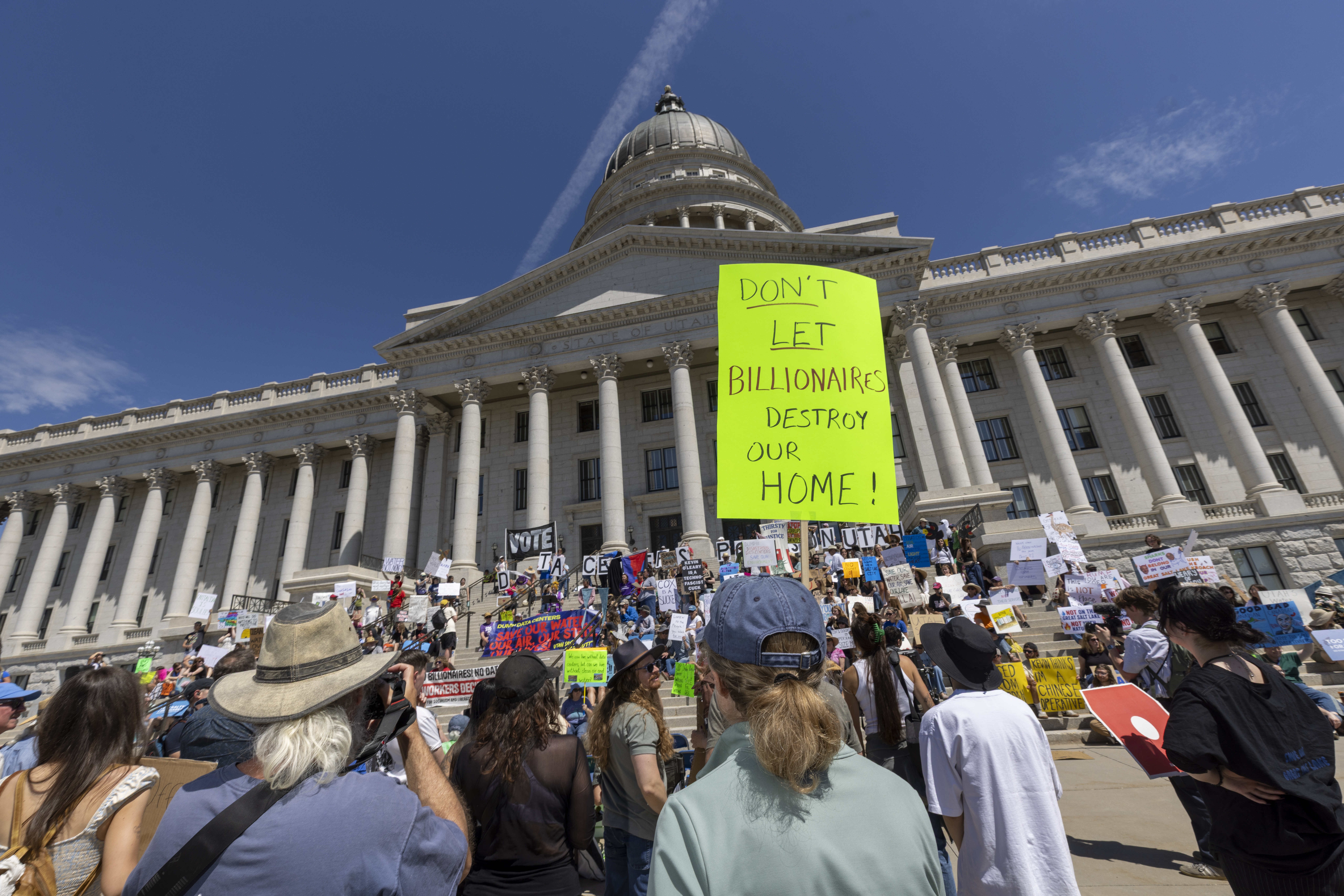 Protesters hold signs in front the of the Utah State Capitol building to oppose the construction of the Stratos data center in Box Elder County on May 23, 2026 in Salt Lake City, Utah. Tech millionaires claim China is behind a wave of local opposition to U.S. data centers, while providing little direct evidence.