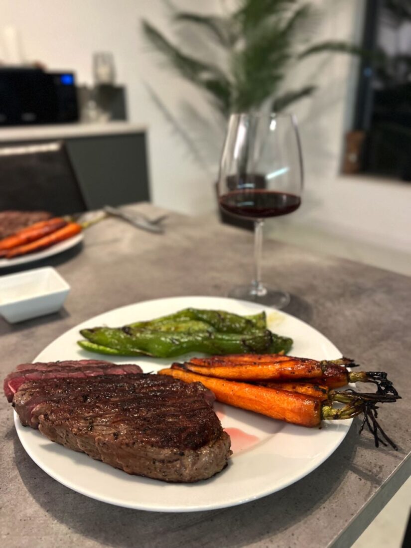 steak dinner with carrots and wine