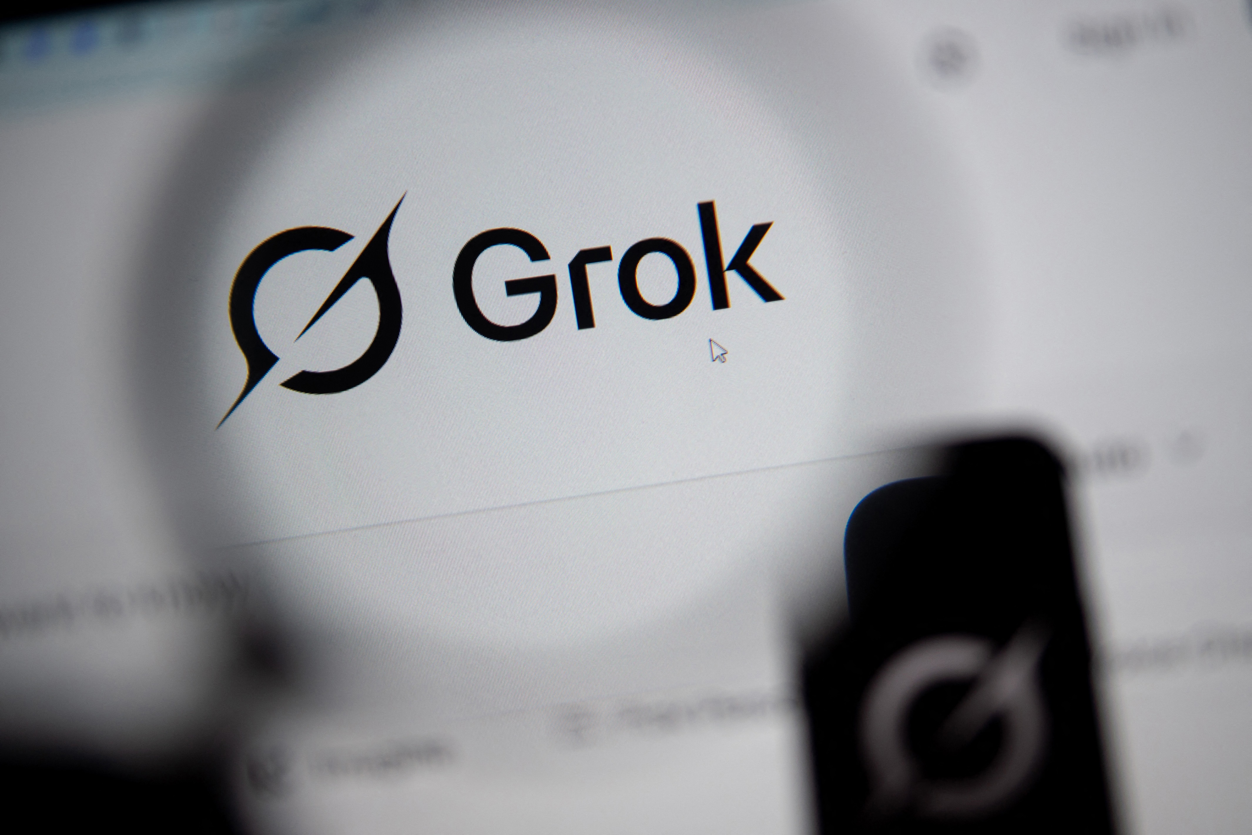 In this photo illustration, the Grok website is seen through a magnifying glass on a computer screen on February 12, 2026. Grok is the AI chatbot built by Elon Musk