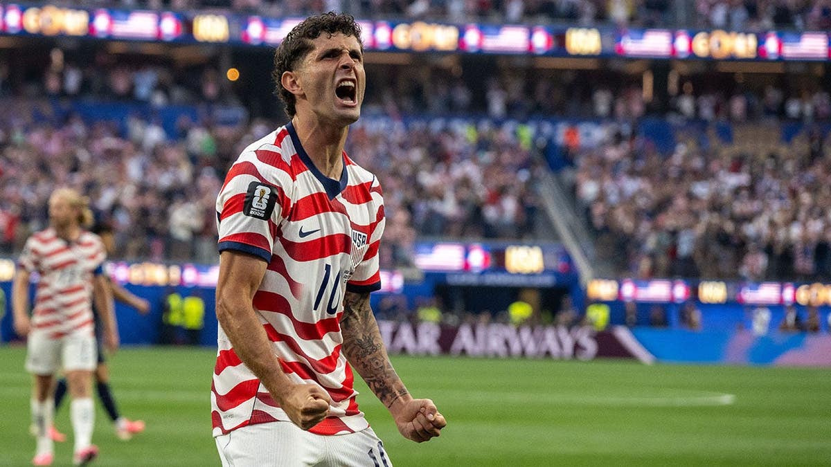 Christian Pulisic celebrates after a goal during a soccer match at Los Angeles Stadium.