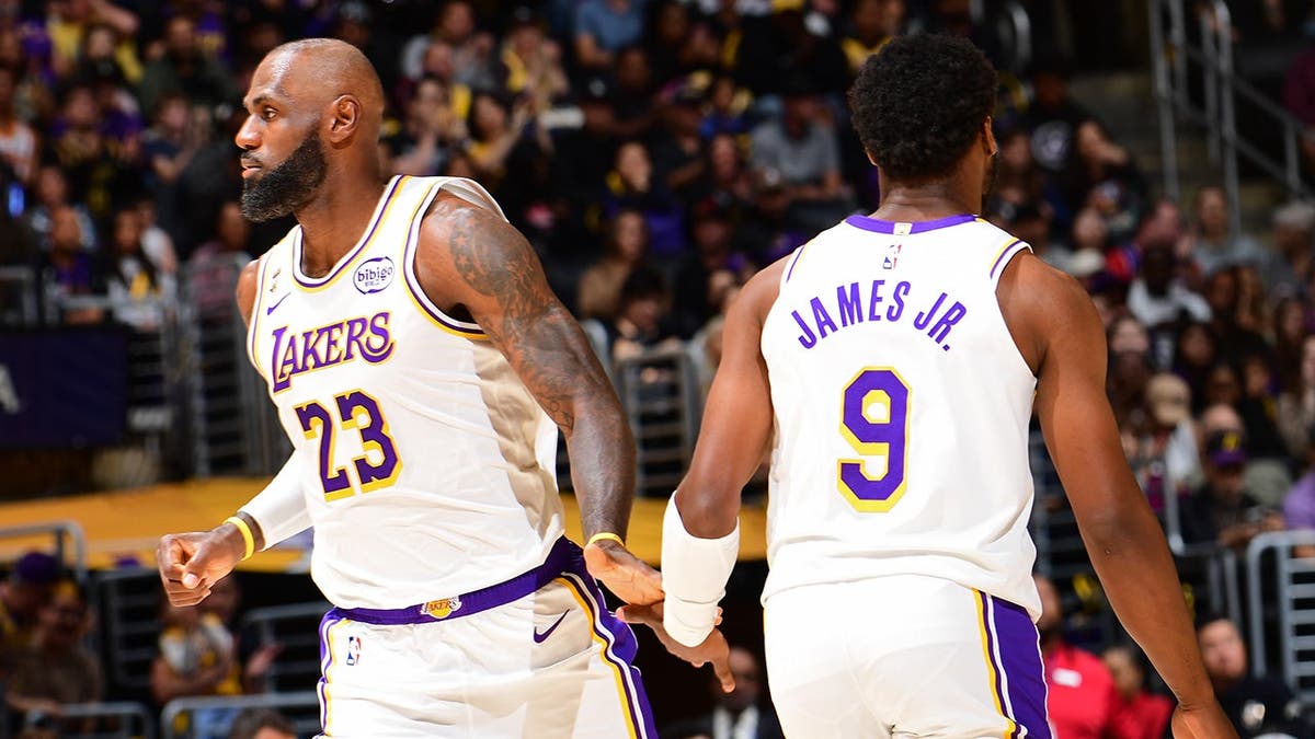 Bronny James and LeBron James interact during a Lakers game