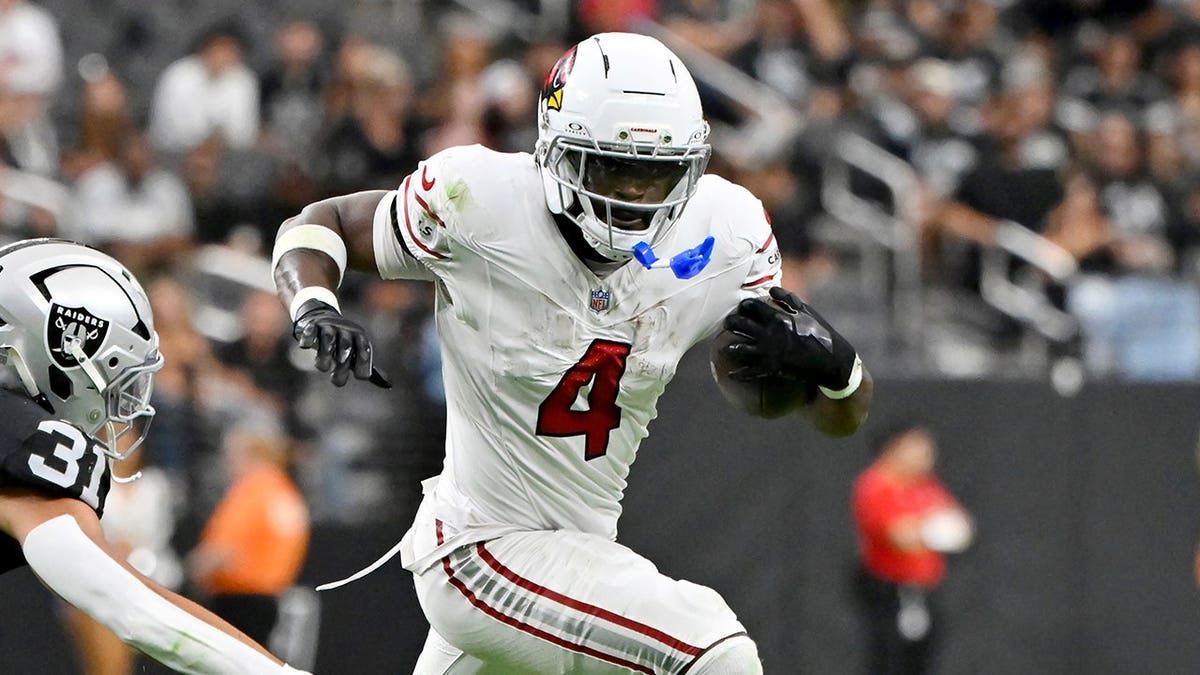 Jeremiyah Love runs past Treydan Stukes during preseason NFL game.