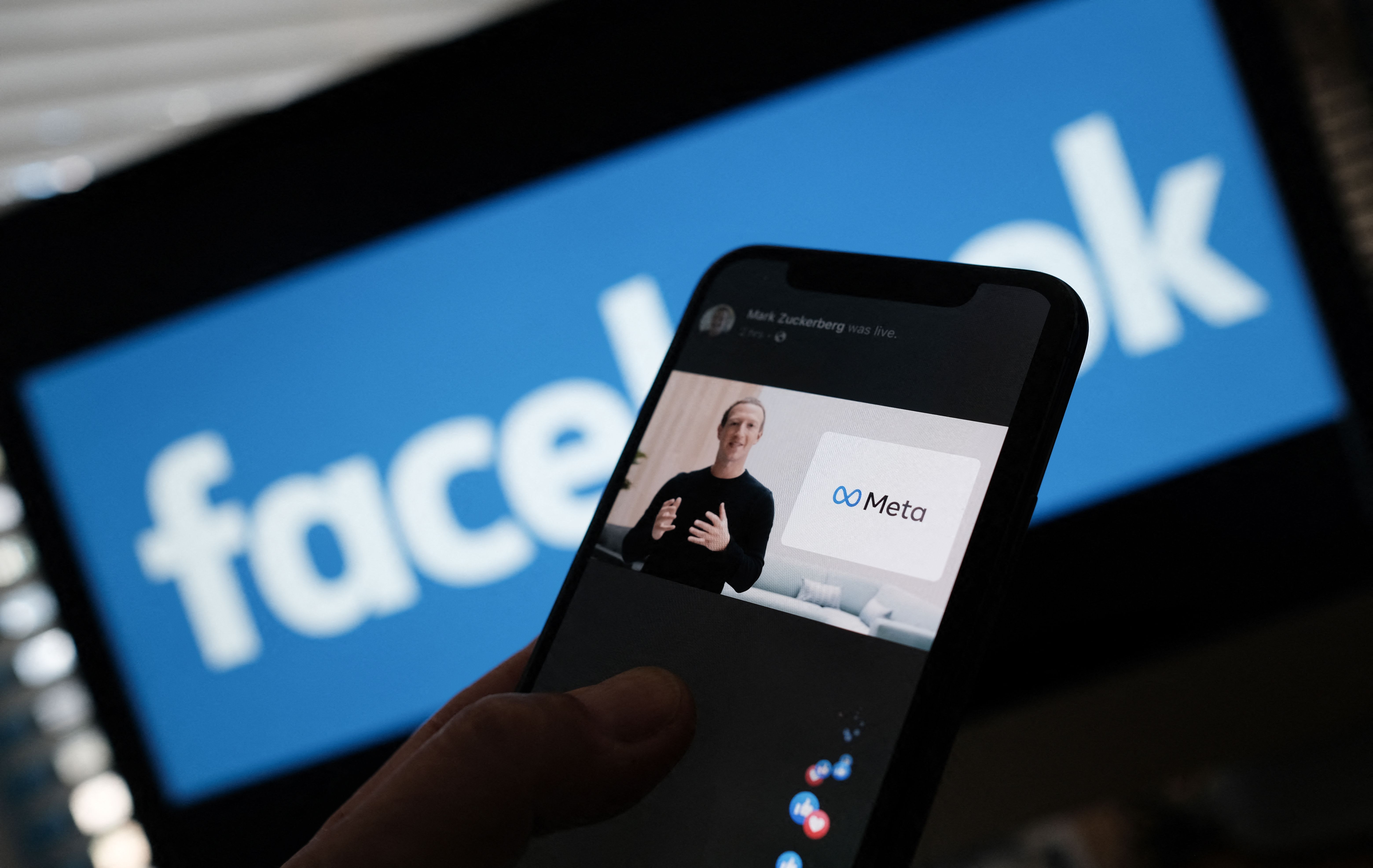 In this illustration photo from Oct. 28, 2021, a person watches on a smartphone as Facebook CEO Mark Zuckerberg unveils the Meta logo.