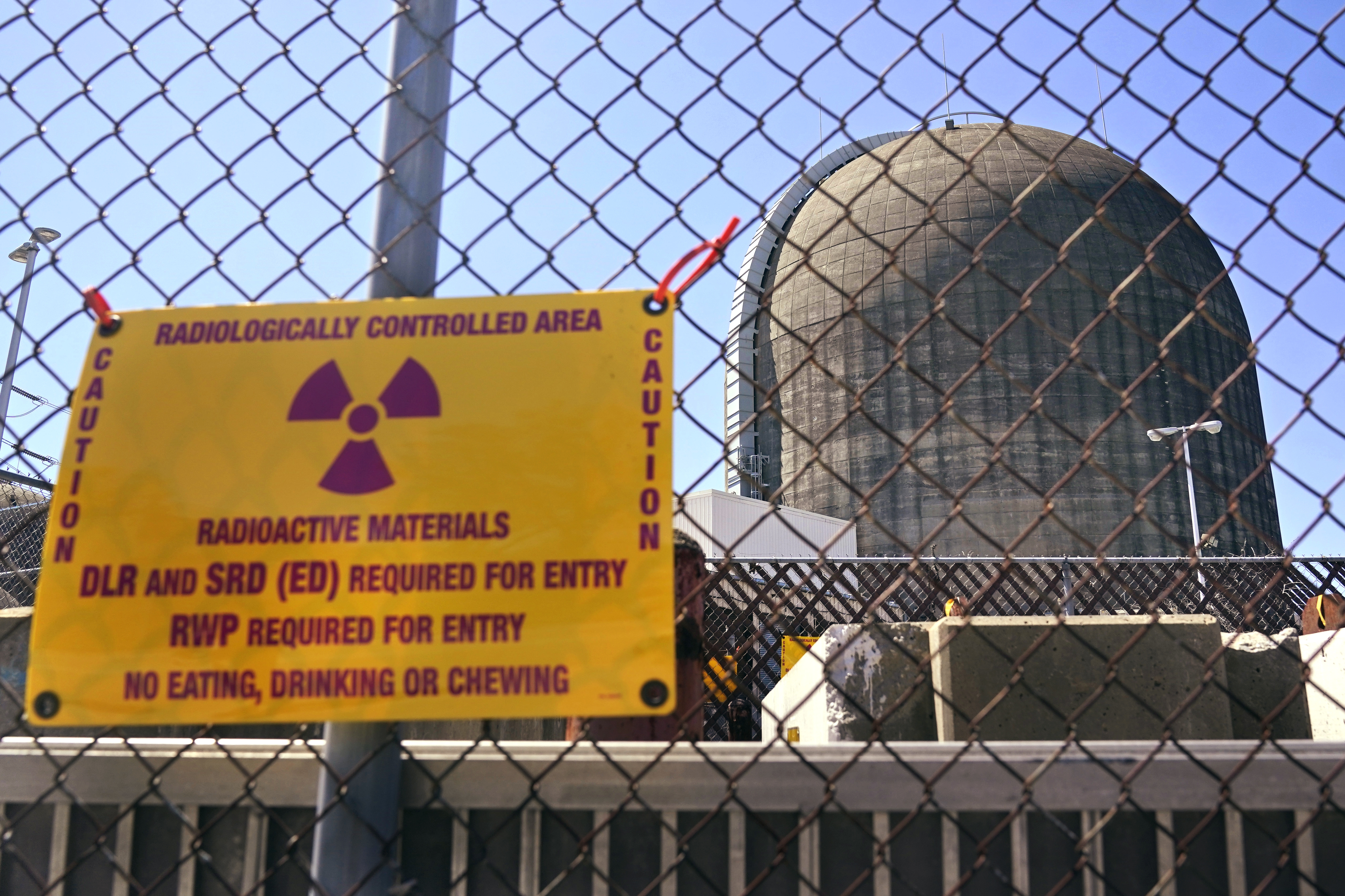 A sign warning of radioactive materials is seen on a fence outside Indian Point Energy Center in Buchanan, N.Y., just days before it closed in 2021. The Trump administration is seeking to overhaul nuclear safety rules to aid a nuclear revival.
